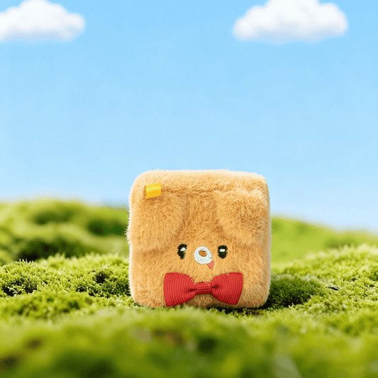 SquarePals at Hi-Creation Week 2026 plush toy with bowtie on a green field under blue sky.