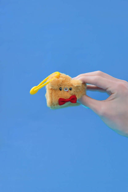 Mini dog squishy plush toys held in hand with a yellow clip and cute bow tie.