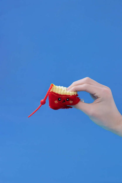 Hand holding a Mini Fries plush toy by Squarepals, featuring a cute design and durable clip strap.